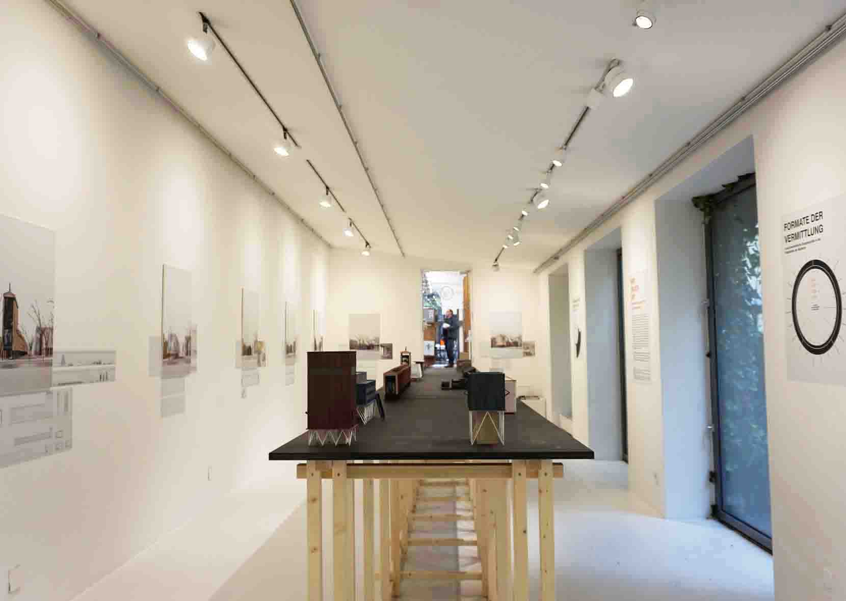 Ausstellungsraum mit langem Tisch mit Architekturmodellen